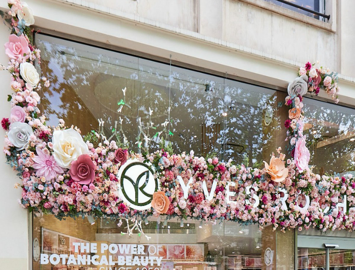 Décor floral extérieur Yves Rocher avec fleurs monumentales réalisées par Atelier Pirina